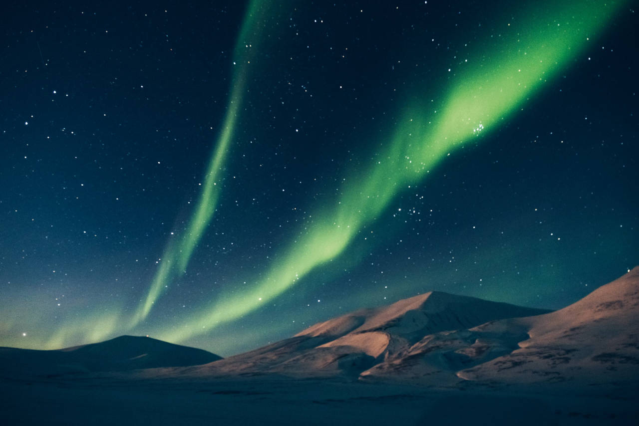 NATURLIG LYS: Dagnordlyset danser over tause fjell i Adventdalen. Foto Dagmara Wojtanowicz