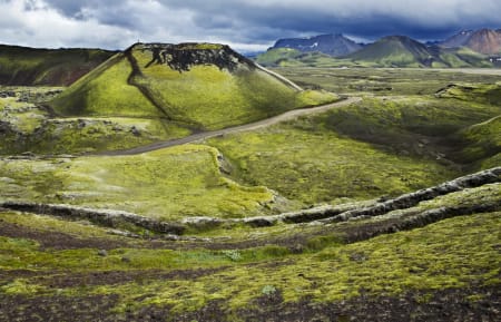 Vulkansk krater med et lite menneske på toppen. Man føler seg fort liten i islandsk natur!