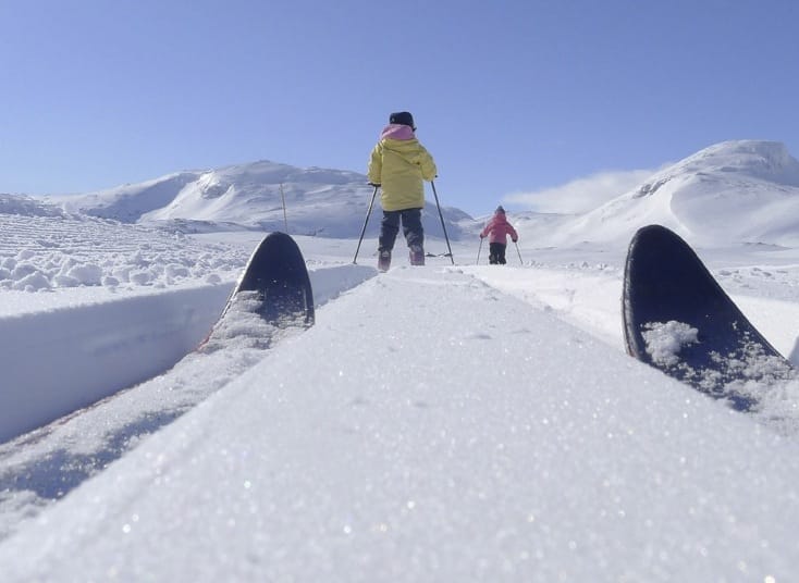 VINTERVAKKERT: Landskapet på Tyin-Filefjell inviterer til skiturer for alle aldersgrupper, alle skiferdigheter og alle typer ski. Her glir Marikken Eidslott (10) og Ea Eidslott (8) inn mot DNTs selvbetjente Sulefjell til venstre og Suletind til høyre. Foto: Eivind Eidslott