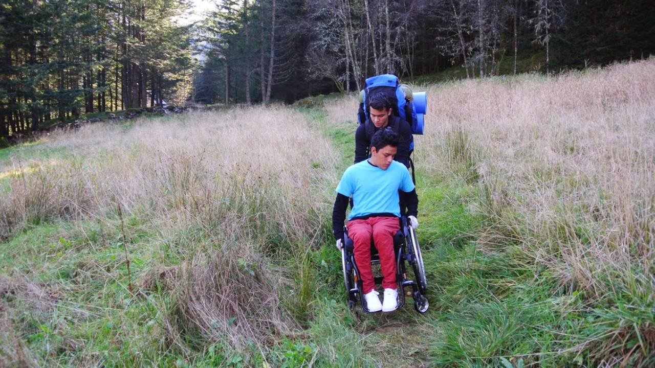 Samarbeid: Yeison Reyes Santos (Columbia) som hjelper Melvin Cornejo Gomez (El Salvador) I rullestolen mangler en fot etter at han som sjuåring tråkka på en landmine i et grenseområde mellom Geriljaen og regjeringssoldater i Colombia. Yeison får oppfølning på Røde Kors Haugland rehabiliteringssenter og er blant de mest aktive UWC-elevene. Foto: Hilde Genberg