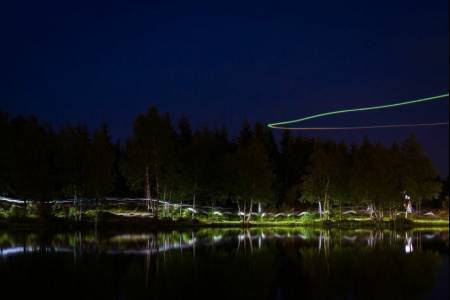 UTFORSK NATTELIVET: Bruk stativ og lang lukkertid nattestid. Her et bilde fra nattorienteringsstafetten Night Hawk ved Øvresetertjern. Over vannet sirkler en drone som filmer løperne. Bildedata: Lukkertid: 25s. Blenderåpning: f/11. Lysfølsomhet: ISO 100. Brennvidde: 64mm. Foto: Snorre Veggan
