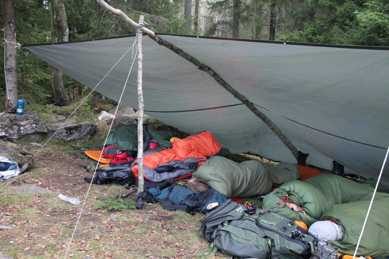 IKKE KOMPLISERT: Det går fint an å lage gapahuk med færre stokker. Her har vi laget en stor variant med bare to stokker i midten, to trær og ellers bare brukt tau for å holde konstruksjonen opp.