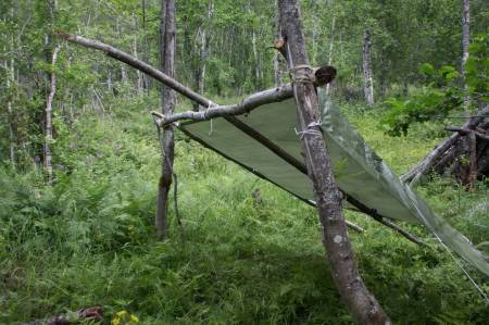 Vi lagde en enkel gapahuk med mye lufting. Ønsker du en tettere og mer værsikker gapahuk trekker du presenningen helt ned til bakken både på sidene og i bakkant.
